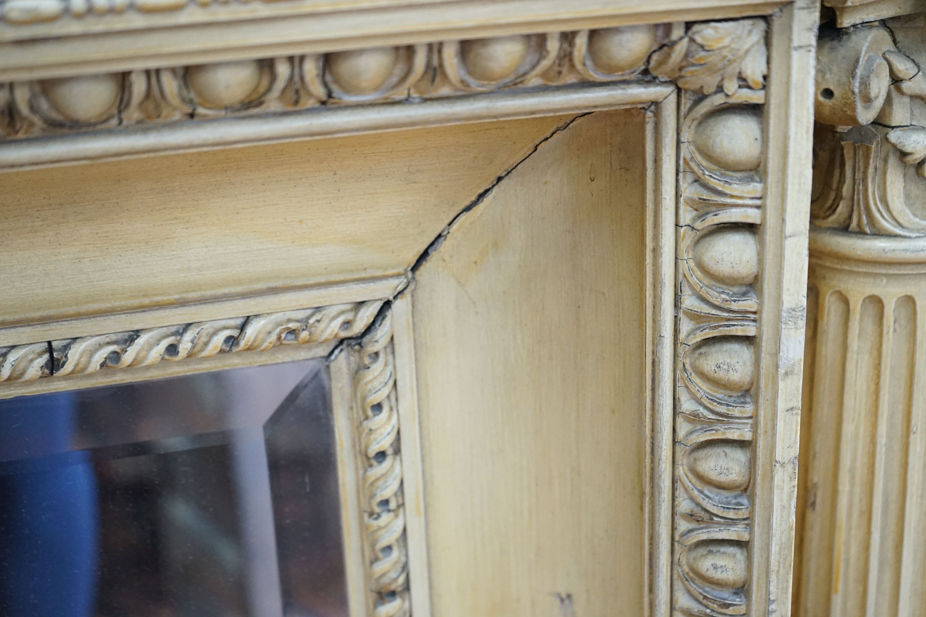 A George III style painted wood and gesso overmantel mirror with rectangular bevelled plate flanked by Corinthian columns, width 152cm, height 122cm